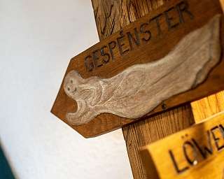 Ein handgeschnitztes Holzschild mit der Aufschrift &#039;GESPNSTER&#039;.