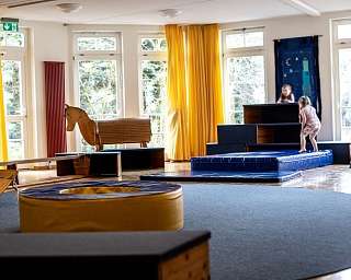Ein heller Raum mit Spielgeräten und Kindern, die spielen.